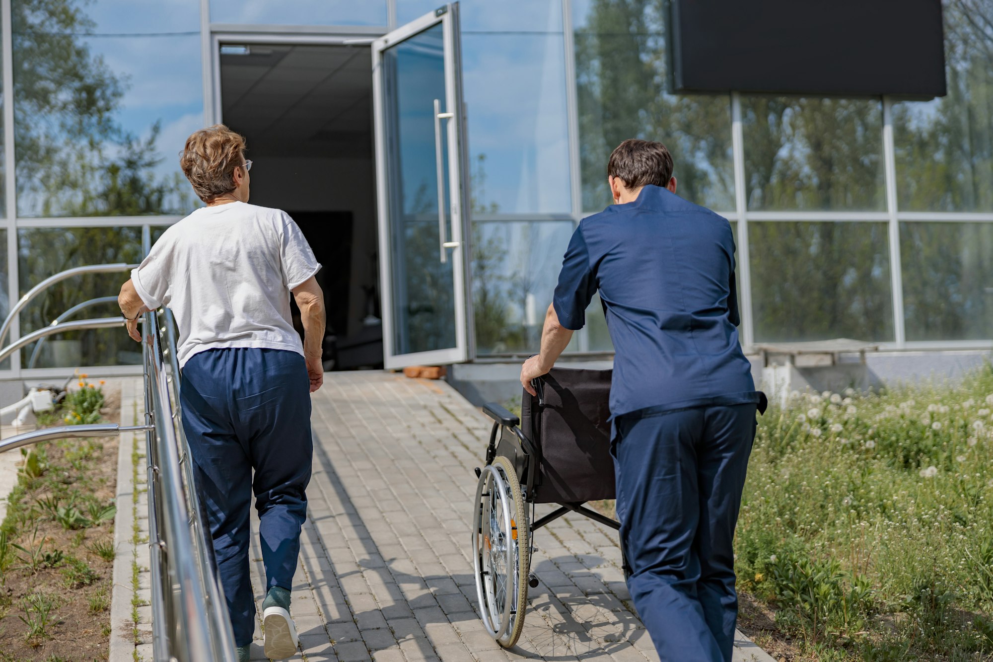 Patient and nurse turn around at clinic after a walk in courtyard